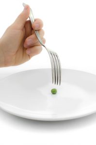 A woman is eating a pea.